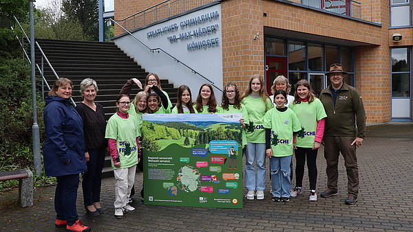 Gruppe Schüler und Lehrer mit Infoschild Biosphärenreservat