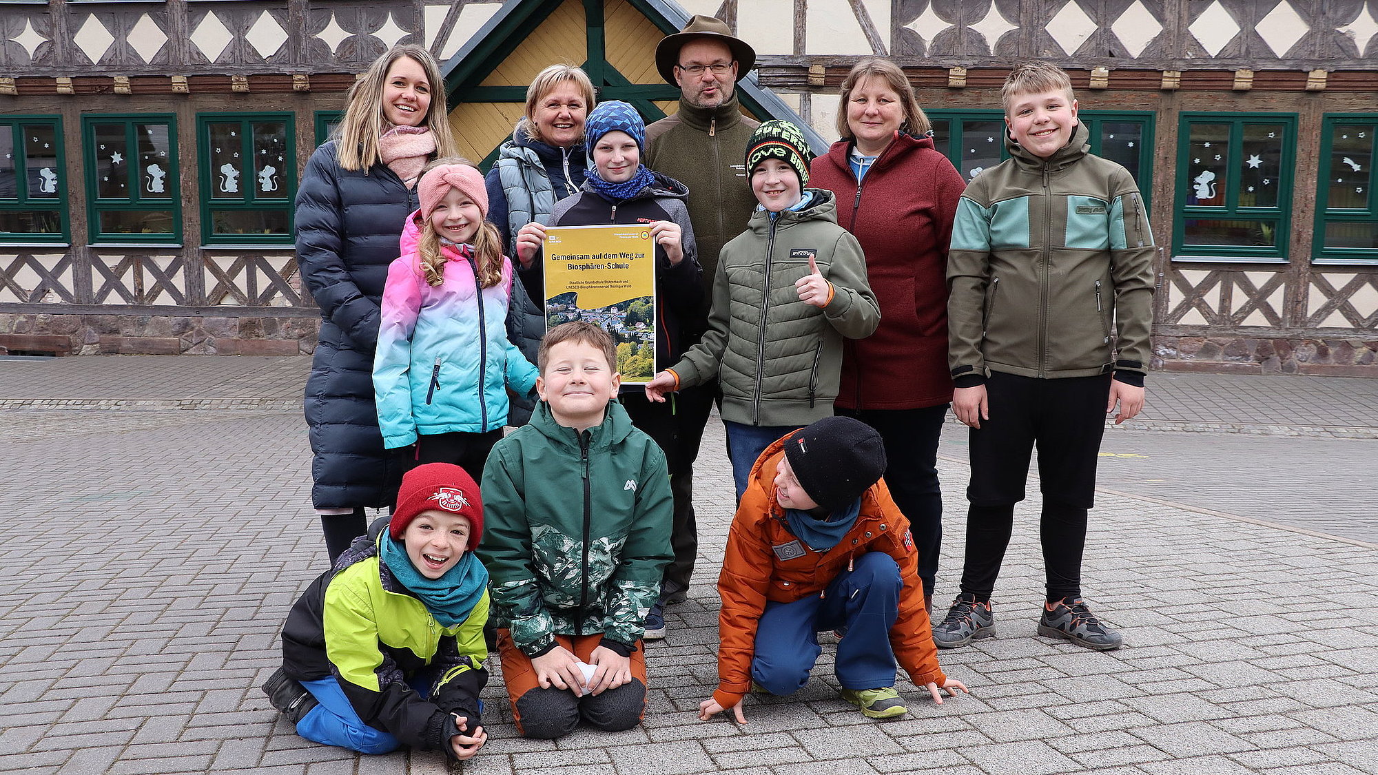 Schüler*innen und Erzieher*innen mit Plakat